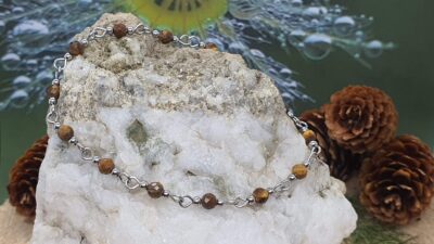 bracelet fin oeil de tigre 4 mm facetté et acier inoxydable sur la pierre devant le bourgeon