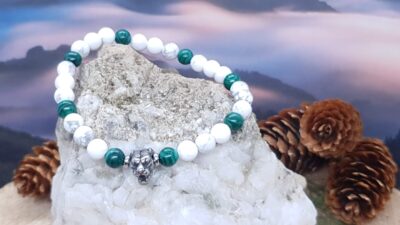 bracelet howlite et malachite 6 mm sur la pierre et devant le ciel nuageux rosé