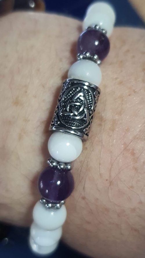 détail du symbole triquetra sur la perle inox du bracelet élastique nacre et améthyste
