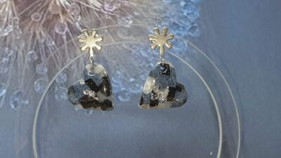 Boucles d'oreilles clou pendant en forme de cœur granit bleu, noir et blanc sur le présentoir en plexiglass