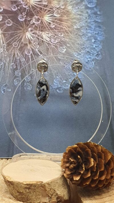 boucles d'oreilles clous pendant navette bleu et noir, sur leur présentoir en plexiglass