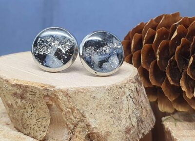 boucles d'oreilles puces tricolores bleu, noir et blanc avec paillettes et design graphique, et feuilles d'argent
