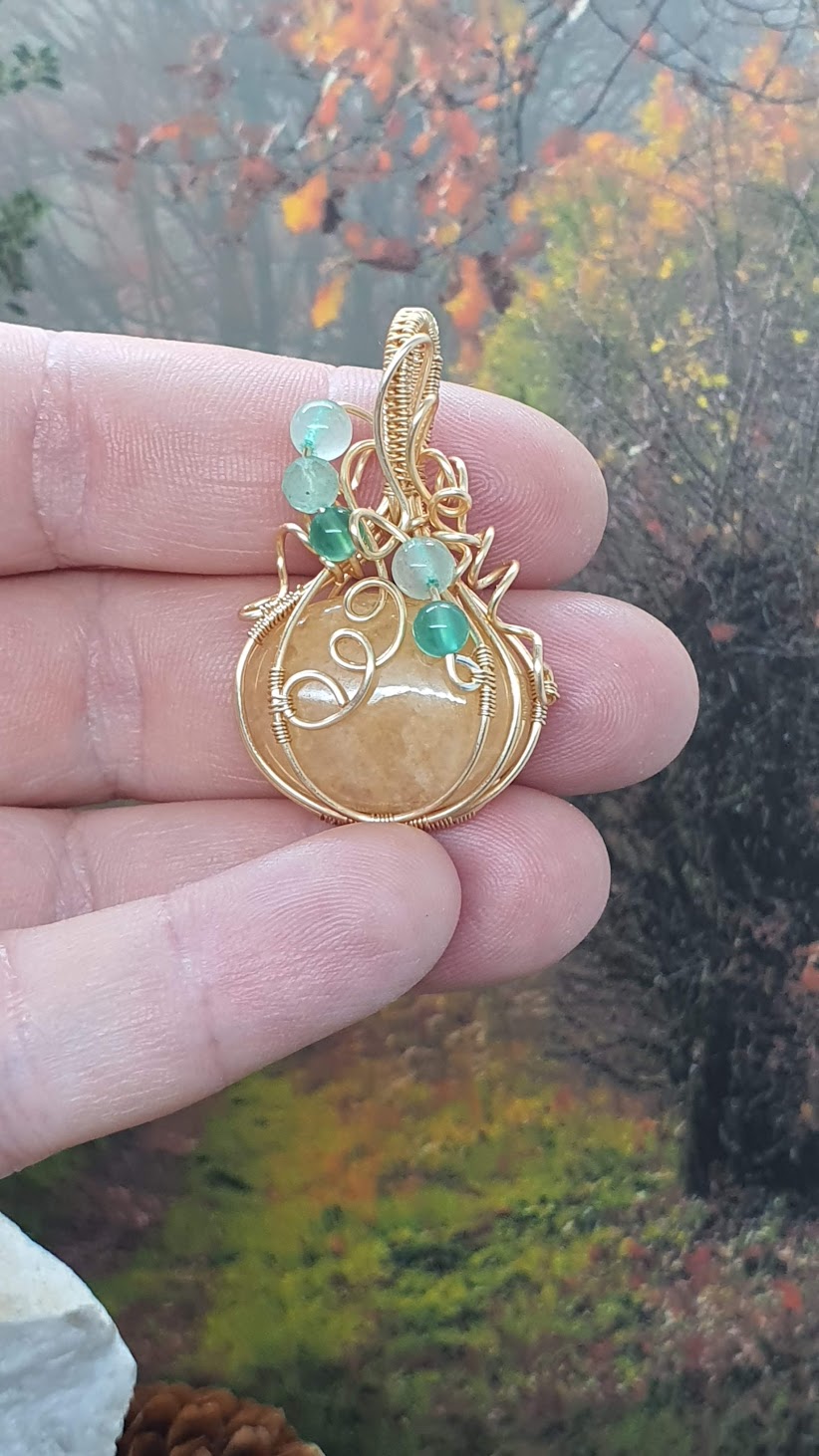 pendentif citrouille en aventurine jaune dans la main