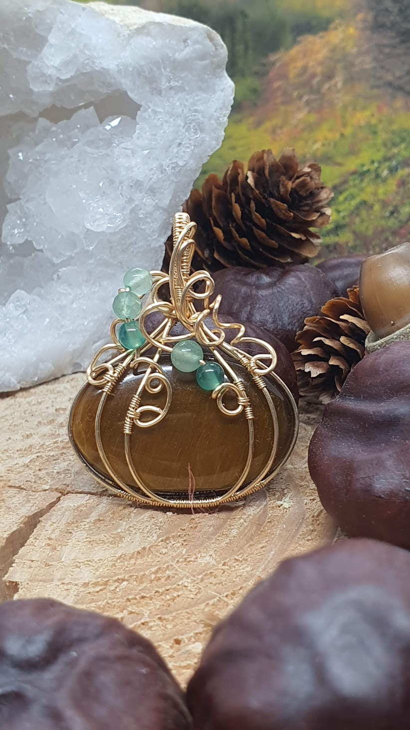 pendentif oeil de tigre citrouille sur fond de forêt automnale