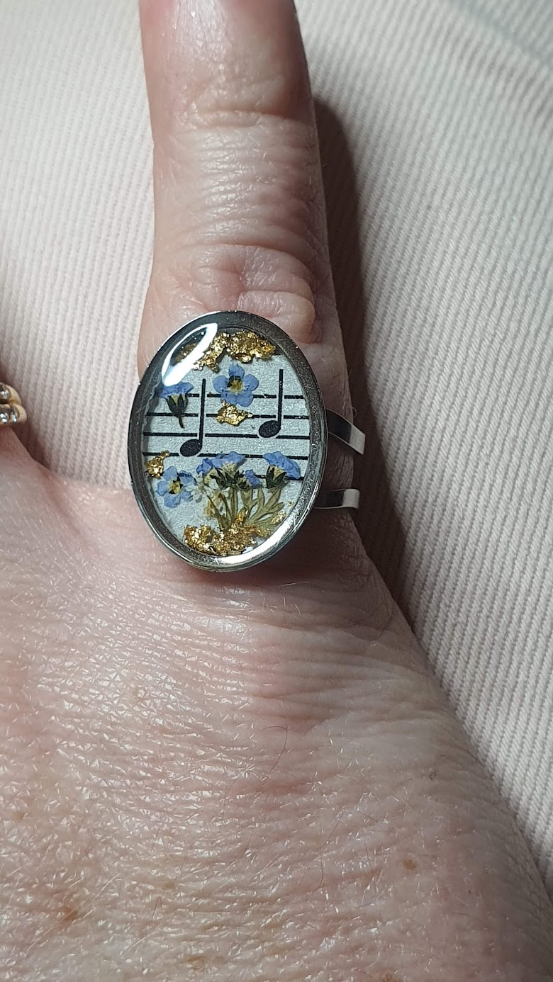 bague inox musique et fleurs séchées résine, portée au petit doigt