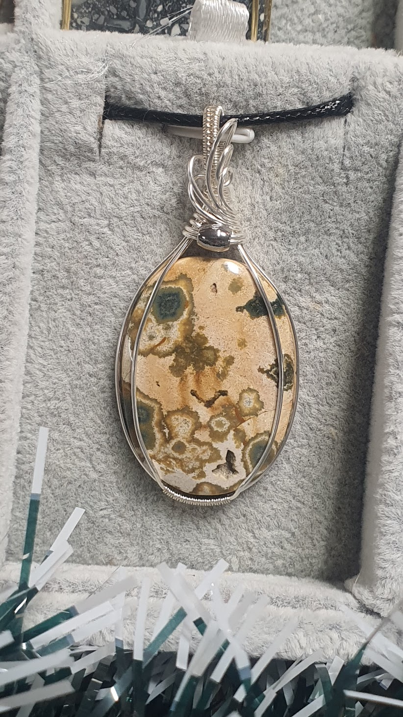 pendentif en jaspe orbiculaire posé dans son plateau gris