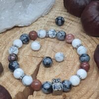 Bracelet rhodonite bicolore noire et rose, howlite prédominante et obsidienne flocon de neige sur le rondin