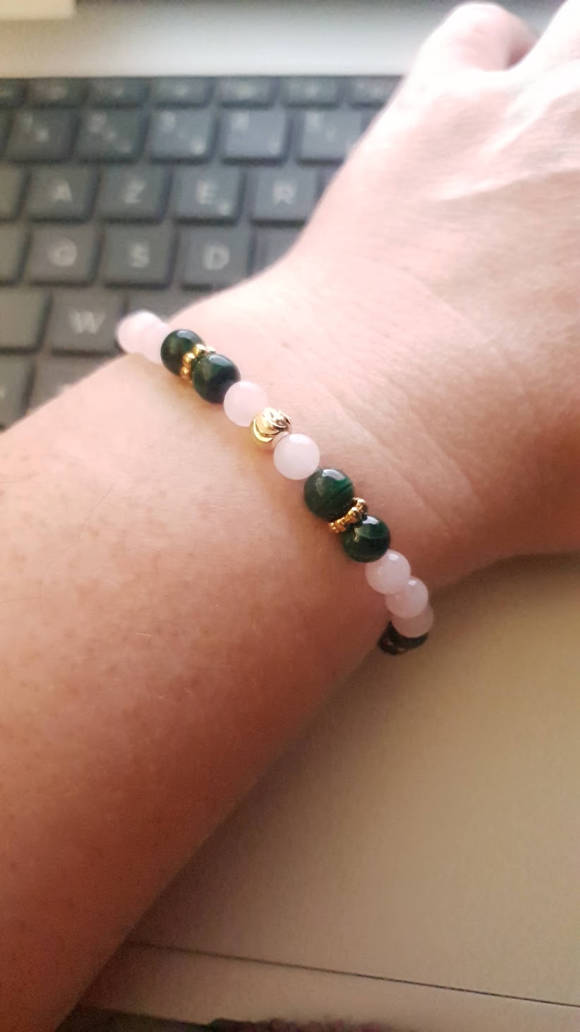 Bracelet malachite et quartz rose en perles 6 mm porté au dessus ordinateur